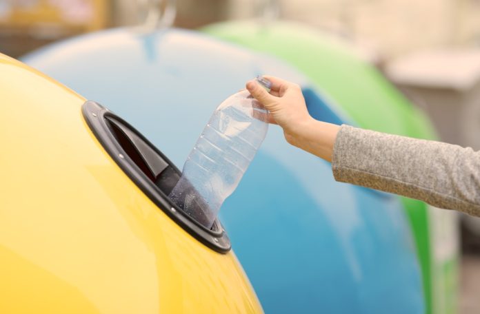 bouteille en plastique mise dans une poubelle jaune