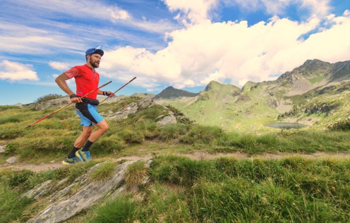 homme qui fait du trailrunning en montagne avec des bâtons