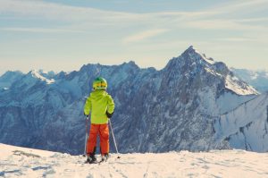 enfant face à la montagne et sur les skis