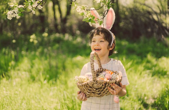 enfant qui tient un panier avec des oeufs de paques