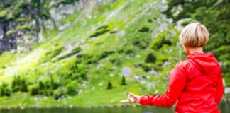 femme qui fait du yoga au bord d'un lac de montagne