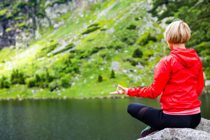 femme qui fait du yoga au bord d'un lac de montagne