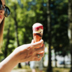 Jeune femme avec des lunettes mangeant de la glace, en plein air